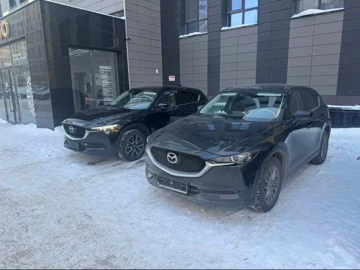 Два чёрных автомобиля Mazda CX-5 во дворе бизнес-центра